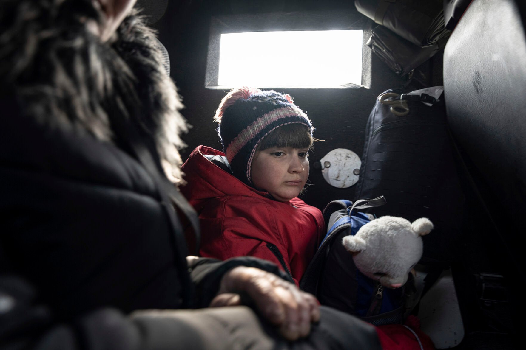 <p>A girl rides with her mother in a van during evacuation by Ukrainian police, March 7 in Avdiivka, Ukraine.</p>