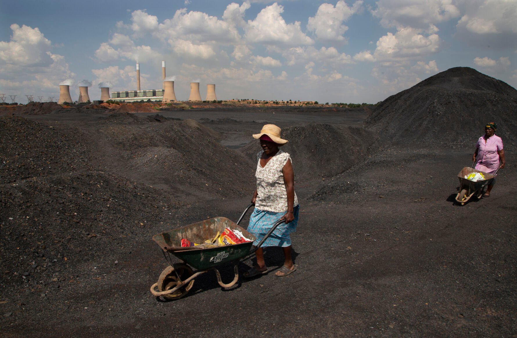 <p>Women push wheelbarrows atop a coal mine dump at the coal-powered Duvha power station Nov. 17, 2022, near Emalahleni, east of Johannesburg.</p>
