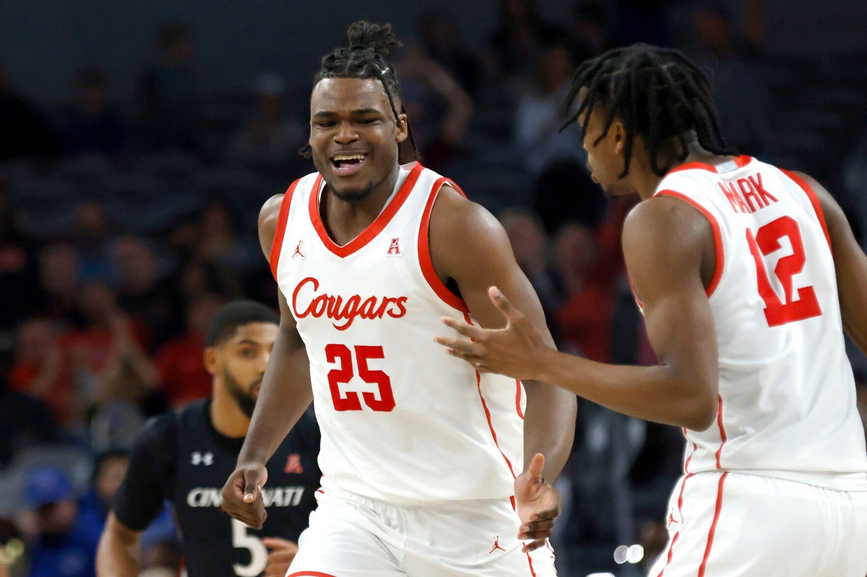 <p>Houston forward Jarace Walker, left, celebrates with teammate and Tramon Mark after a slam dunk against Cincinnati on March 11.</p>