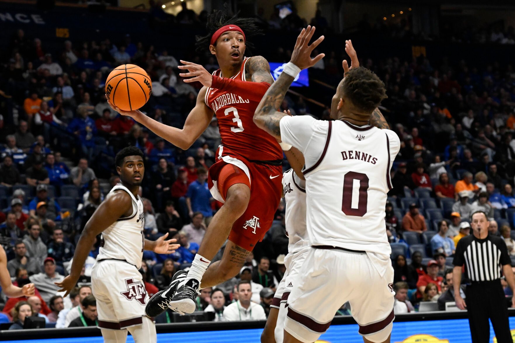 <p>Arkansas guard Nick Smith Jr. looks to pass as Texas A&M guard Dexter Dennis defends during their March 10 game.</p>