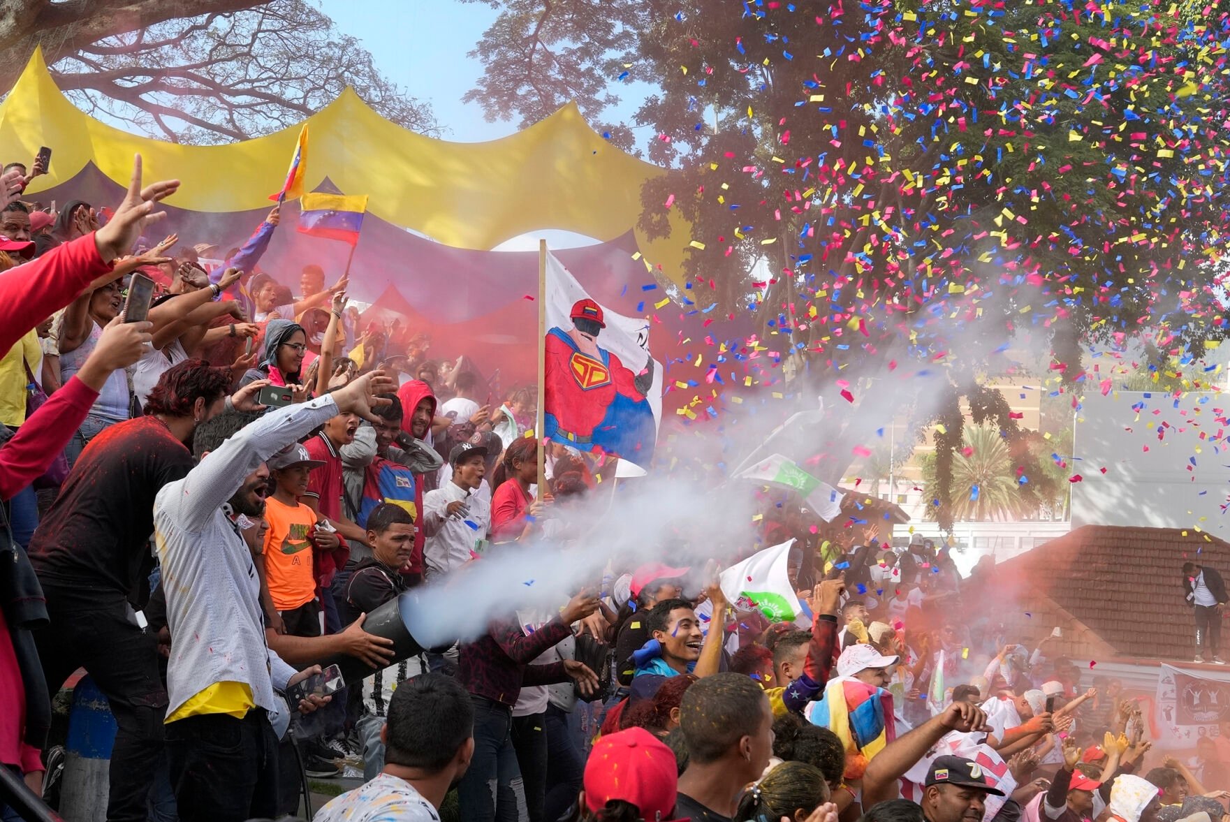 <p>A banner of President Nicolás Maduro depicted as a superhero is held amid supporters Feb. 12 as they are showered in confetti during an event marking Youth Day at the Miraflores Presidential Palace in Caracas, Venezuela.</p>