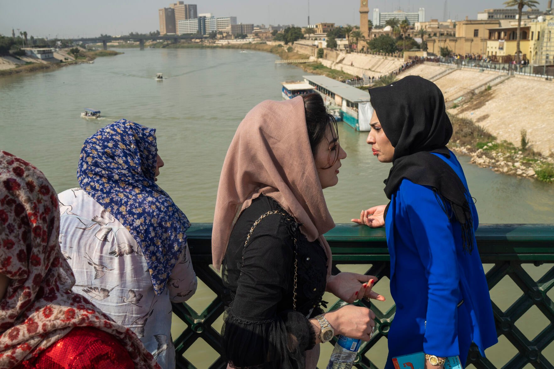<p>Women stand on the "martyrs' bridge" spanning the Tigris River in Baghdad, Iraq, Friday, Feb. 24, 2023. (AP Photo/Jerome Delay)</p>