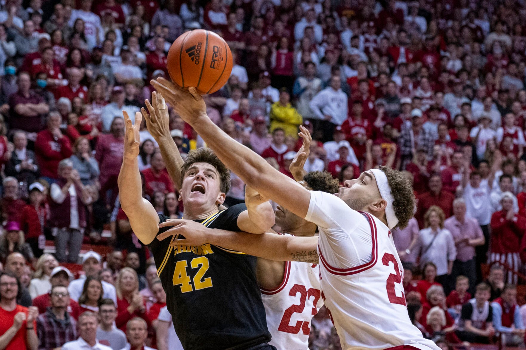 <p>Michigan forward Will Tschetter, left, and Indiana forward Race Thompson battle for a rebound during the first half of Sunday's game in Bloomington, Ind.</p>