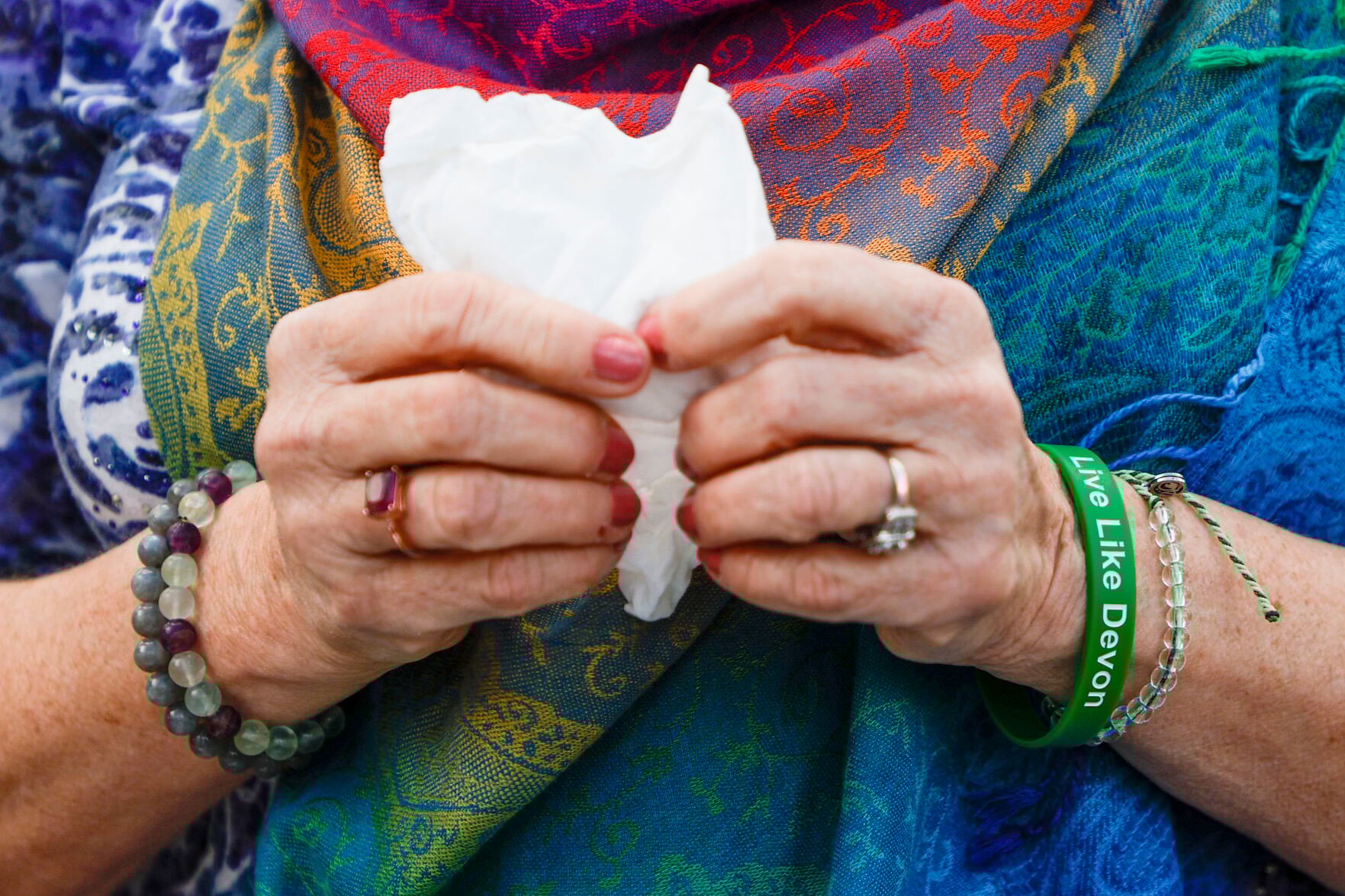 <p>Laura McCullough holds onto tissues after speaking to her son inside the wind phone. Her left wrist sports a memory bracelet in his favorite color. She says she never hears his voice, but she knows he hears her. </p>