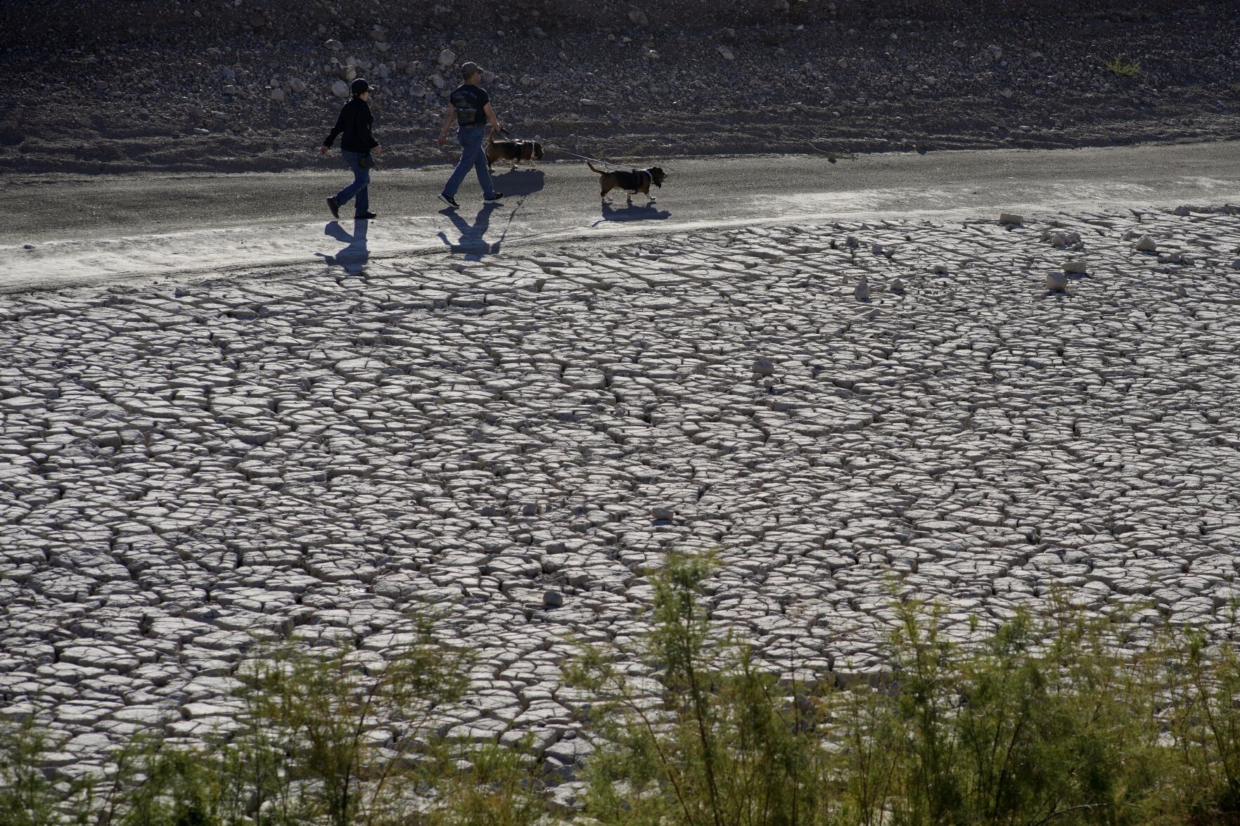 <p>People walk by cracked earth in an area once under the water of Lake Mead at the Lake Mead National Recreation Area, Jan. 27, 2023, near Boulder City, Nevada.</p>
