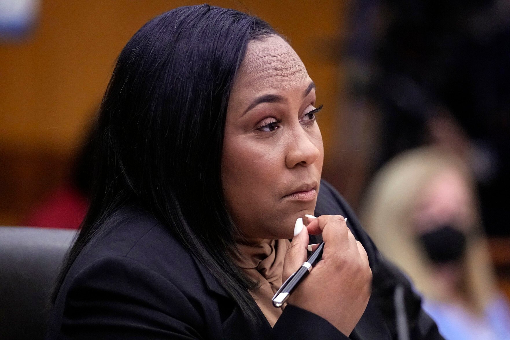 <p>FILE - Fulton County District Attorney Fani Willis watches proceedings during a hearing to decide if the final report by a special grand jury looking into possible interference in the 2020 presidential election can be released Jan. 24, 2023, in Atlanta. Lawyers for former President Donald Trump on Monday, March 20, 2023 filed a motion seeking to throw out the special grand jury investigation and disqualify Willis. (AP Photo/John Bazemore, File)</p>