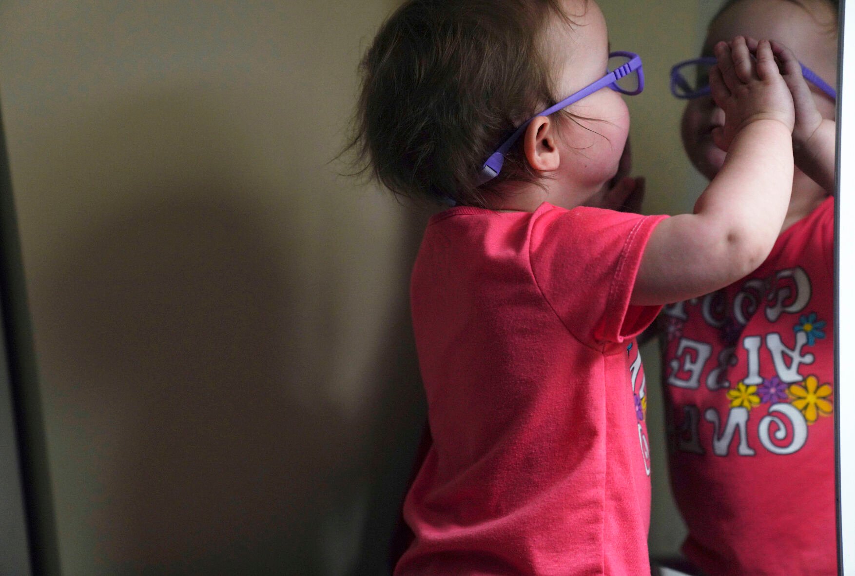 <p>The Hackneys’ daughter looks at her reflection in a bedroom mirror during a supervised visit Nov. 17 at her parent's home in Oakdale, Pa. At 8 months old, the young child was taken from her parents' custody after arriving at the hospital severely dehydrated and malnourished.</p>