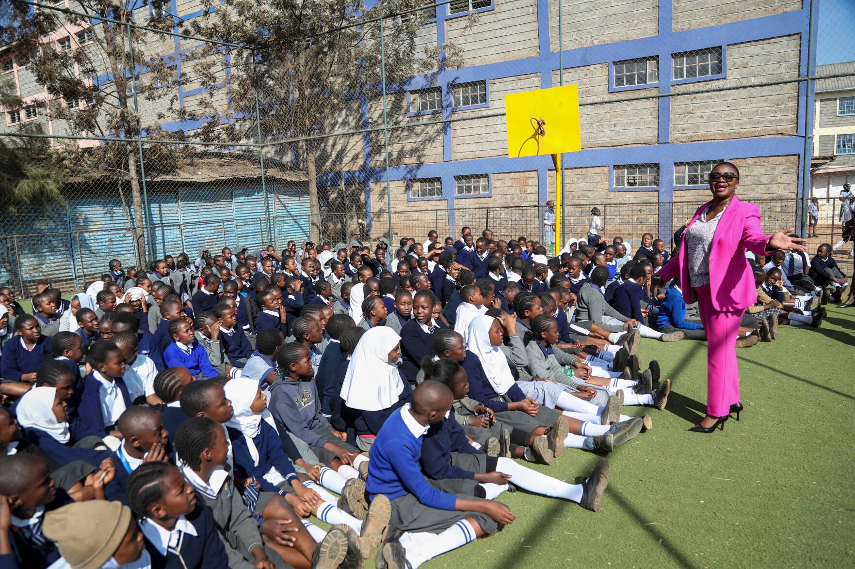 <p>Kenyan Sen. Gloria Orwoba, right, distributes free sanitary pads to girls at Mukuru Community Center Primary school, while explaining to them the need to openly discuss menstruation to end period shaming, March 7 in the Mukuru neighborhood on the outskirts of Nairobi, Kenya.</p>