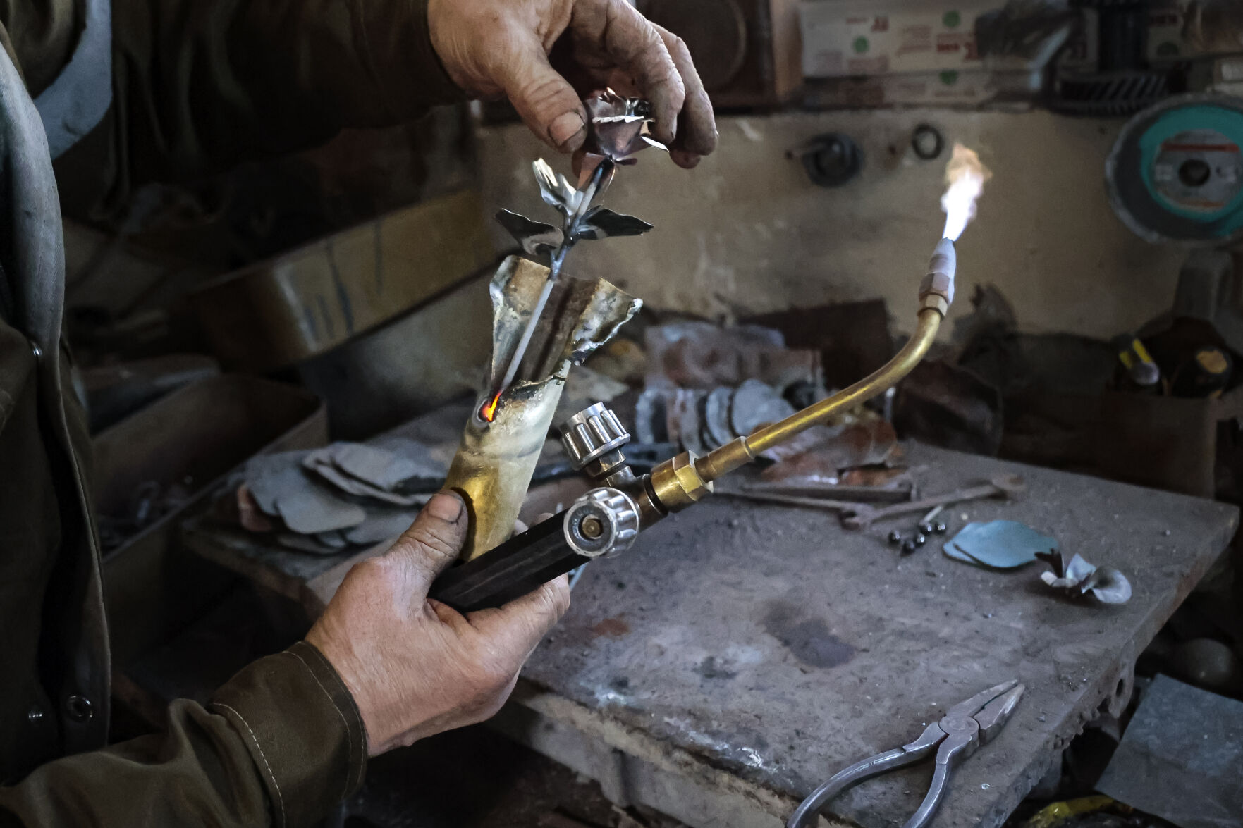 <p>Viktor Mikhalev works in a workshop in his house in Donetsk, Russian-controlled Donetsk region, eastern Ukraine, Saturday, March 4, 2023. Mikhalev is transforming weapons and ammunition into flowers of war. Mikhalev, trained as a welder, lives and works in a house whose fence and door are decorated with forged flowers and grapes. (AP Photo/Alexei Alexandrov)</p>