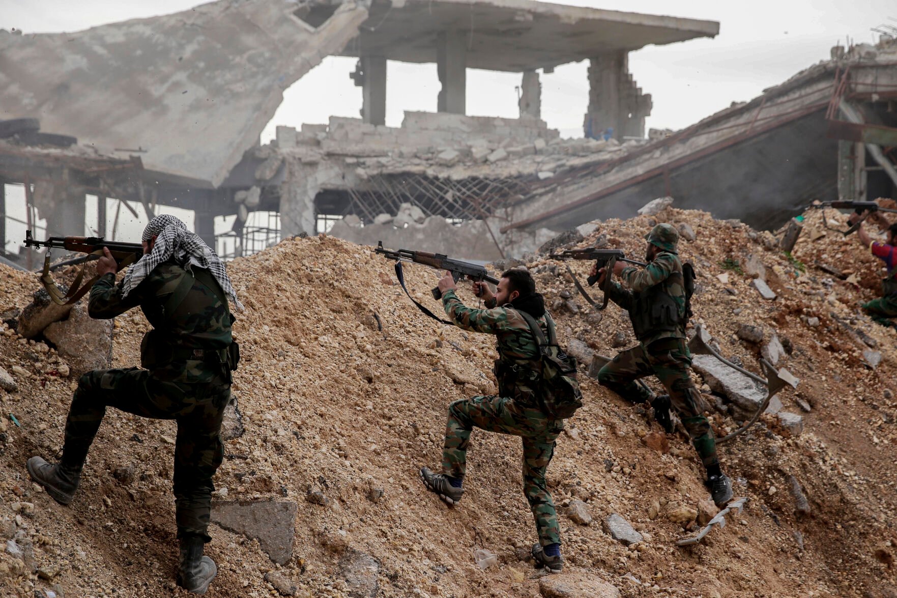 <p>Syrian army soldiers fire their weapons during a battle with rebel fighters Dec. 5, 2016, at the Ramouseh front line, east of Aleppo, Syria.</p>