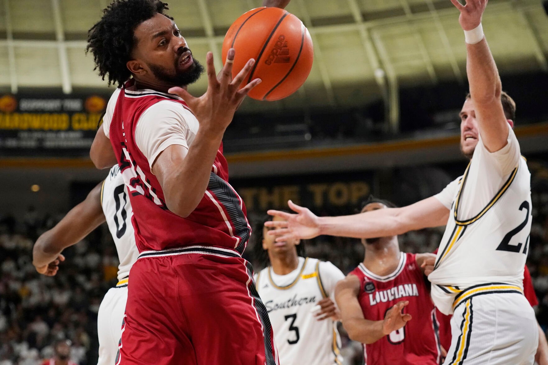 <p>Louisiana forward Jordan Brown reaches for a rebound while Southern Mississippi forward Felipe Haase defends during their Feb. 9 game.</p>