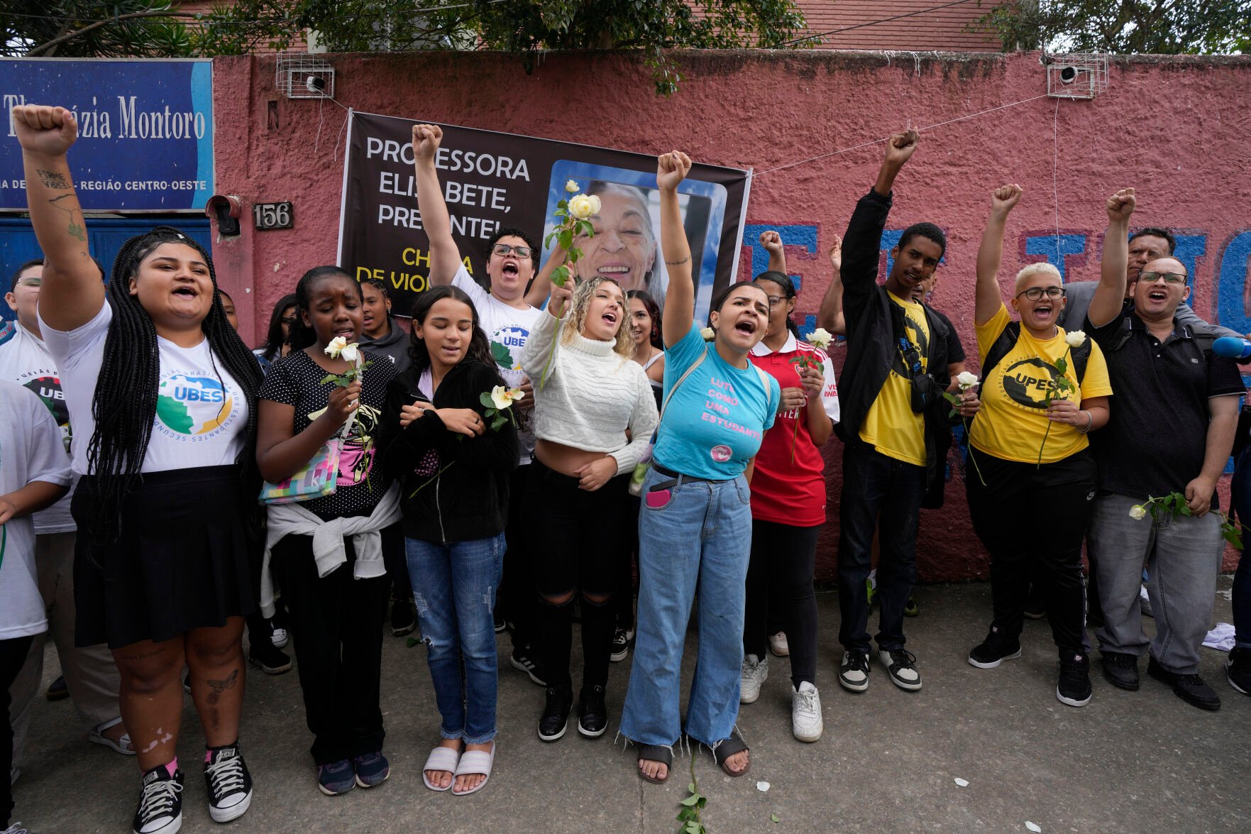 <p>Students of the Thomazia Montoro public school shout for peace and against violence March 28 in front of a banner of Elisabete Tenreiro, a 71-year-old teacher who was stabbed to death the previous day, during a vigil at their school in Sao Paulo, Brazil.</p>