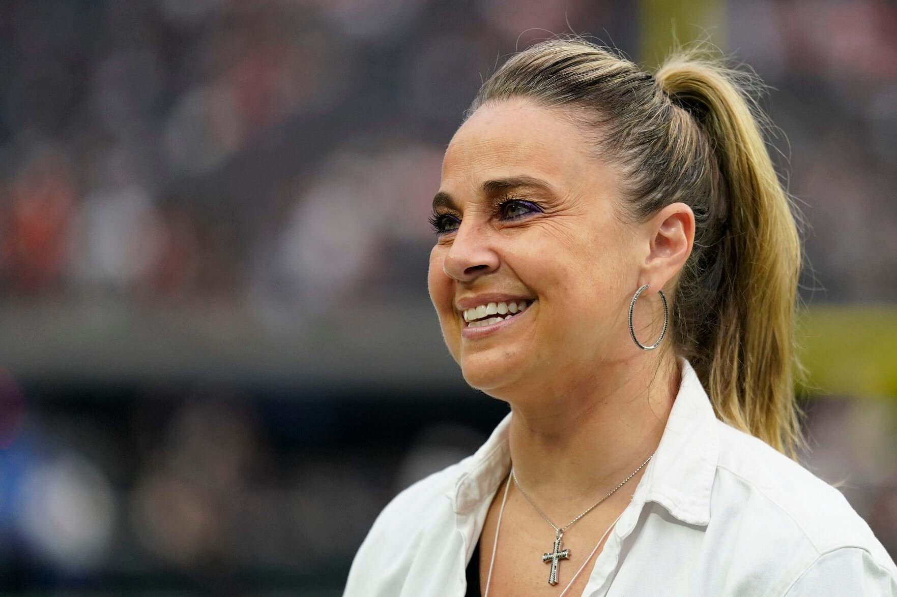 <p>Las Vegas Aces coach Becky Hammon stands on the field before an Oct. 2, 2022, NFL game between the Denver Broncos and Las Vegas Raiders in Las Vegas.</p>