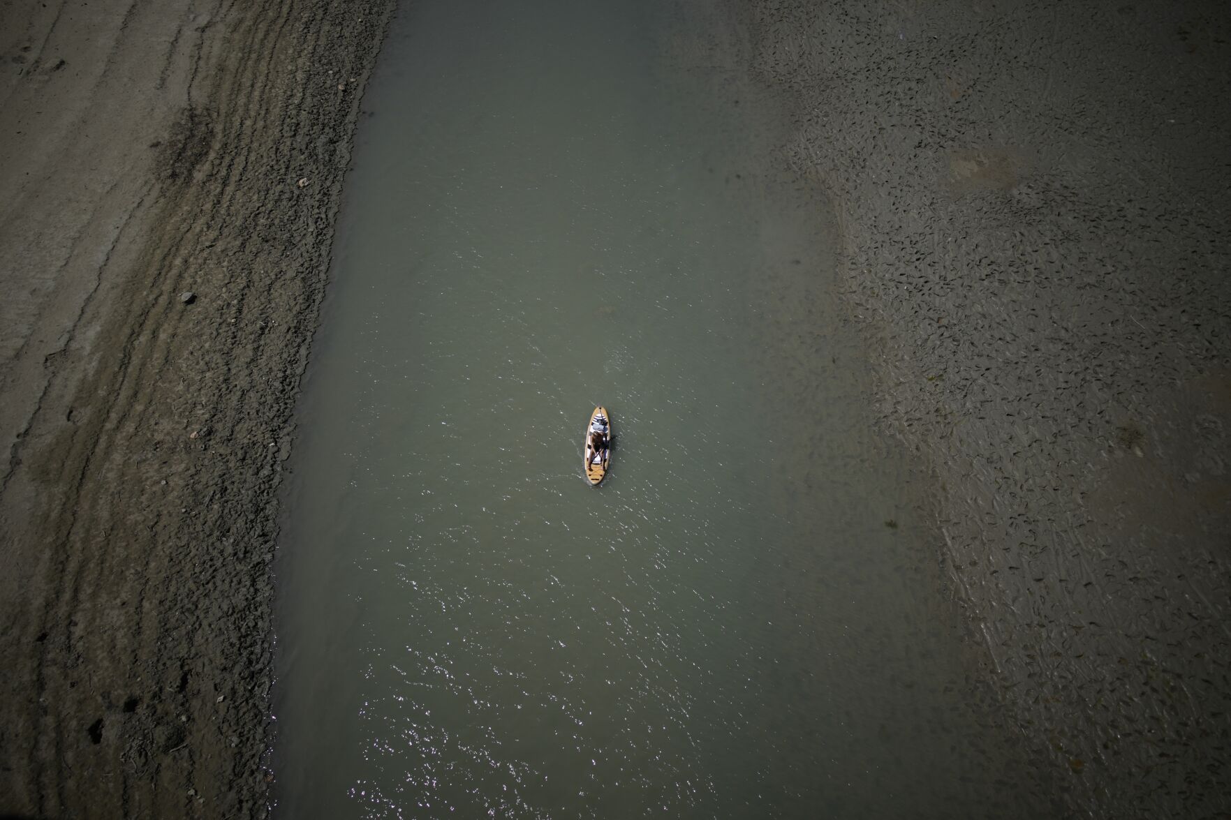 <p>A paddle boarder passes through a drying portion of the Verdon Gorge in southern France, on Aug. 9, 2022. </p>
