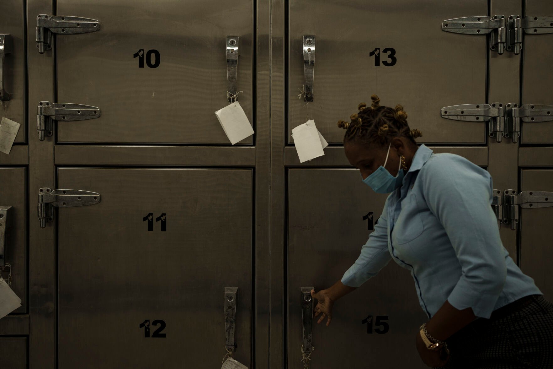 <p>A mortuary technician opens the door of a refrigerator used to store the remains of migrants recovered from a Mauritanian boat that appeared drifting near the island of Trinidad and Tobago.</p>