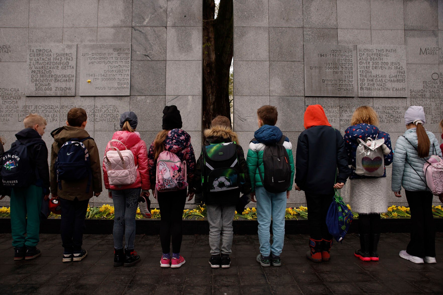 <p>Children attend a minute of silence at The Umschlagplatz monument Wednesday during personal unofficial observances marking the 80th anniversary of the Warsaw Ghetto Uprising in Warsaw, Poland.</p>