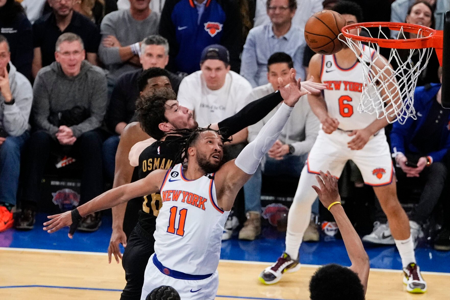 <p>The Knicks' Jalen Brunson, front, drives past the Cavaliers' Cedi Osman during the first half of Friday's first-round playoff game in New York.</p>