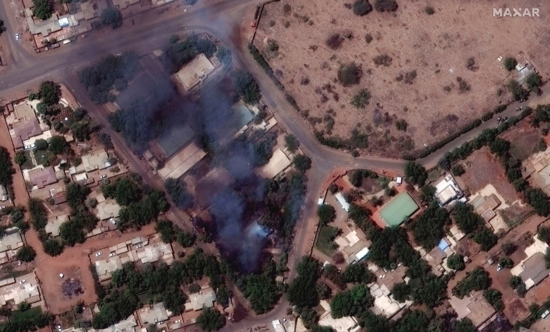 <p>Buildings burn and military patrol Monday northeast of Khartoum International Airport, Sudan.</p>