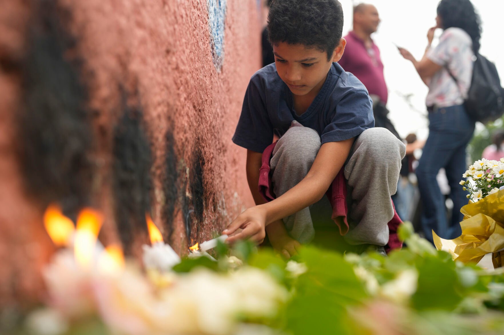 <p>A student from the Thomazia Montoro public school lights a candle March 28 during a vigil asking for peace the day after a student stabbed a teacher to death at the school in Sao Paulo, Brazil.</p>