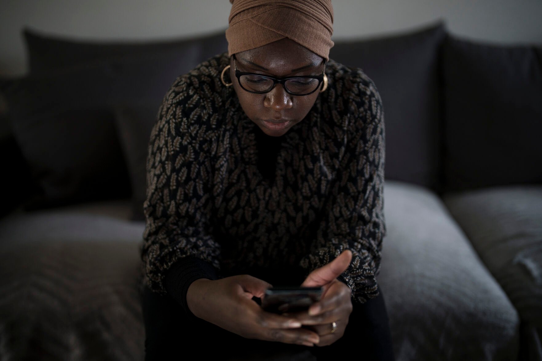 <p>May Sow, whose nephew, Alassane Sow, went missing after boarding a boat from Mauritania in an attempt to reach Europe, looks at her phone Nov. 22 at her home in Orleans. She received DNA results confirming Alassane's body was among those recovered on a boat that was found in the Caribbean.</p>