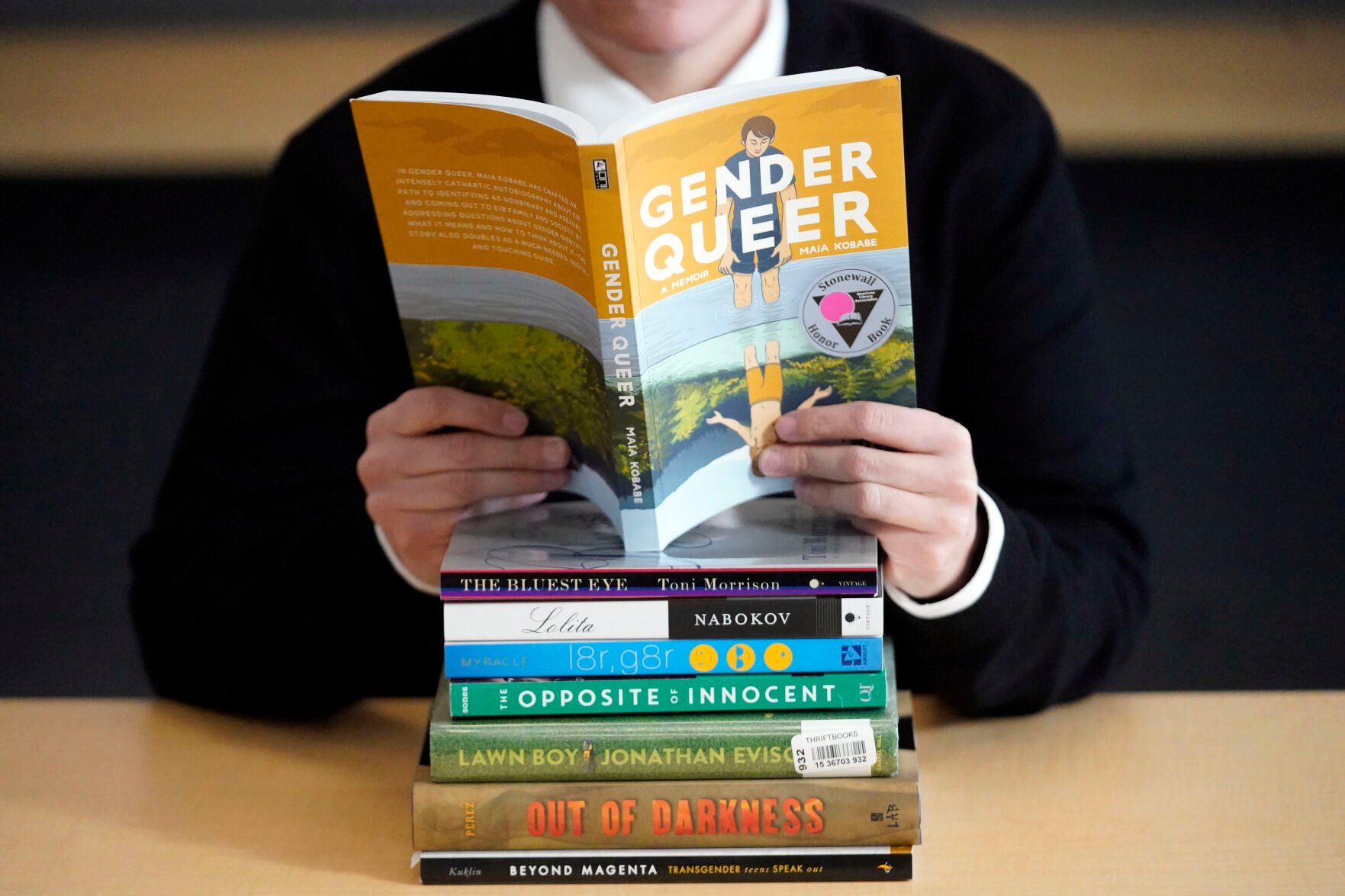 <p>FILE - Amanda Darrow, director of youth, family and education programs at the Utah Pride Center, poses with books that have been the subject of complaints from parents on Dec. 16, 2021, in Salt Lake City. With legislators in Florida barring even the mention of being gay in classrooms and similar restrictions being considered in other states, books with LGBTQ+ themes remain the most likely targets of bans or attempted bans at public schools and libraries around the country, according to a new report Monday, April 24, 2023. Maia Kobabe’s graphic memoir “Gender Queer,” was the most “challenged” book of 2022, the second consecutive year it has topped the list. (AP Photo/Rick Bowmer, File)</p>
