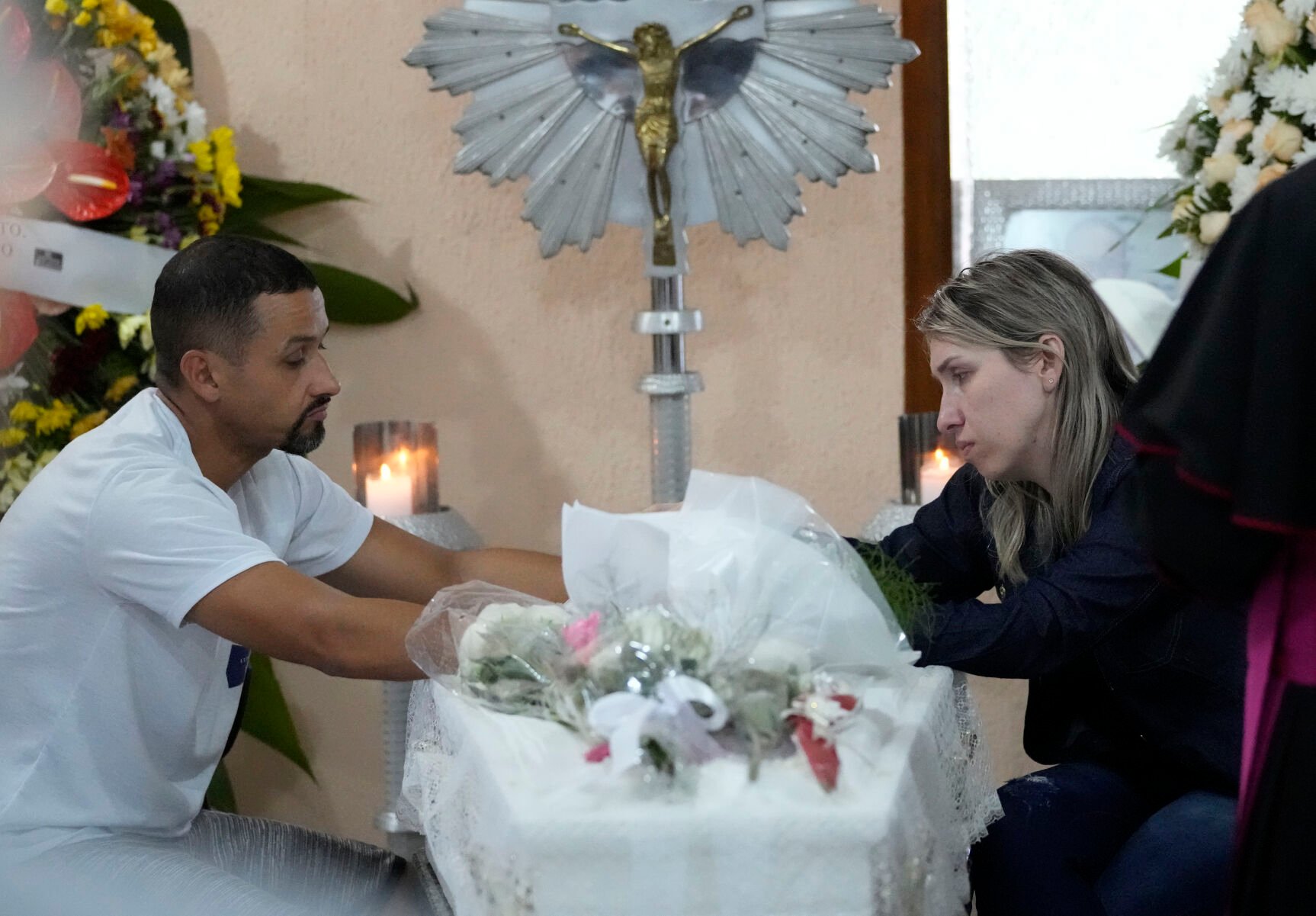 <p>Parents sit April 6 with the coffin that contains the remains of their 7-year-old daughter Larissa Maia Toldo, who was killed by a man with a hatchet inside a day care center, during a wake at the Sao Jose cemetery in Blumenau, Santa Catarina state, Brazil.</p>