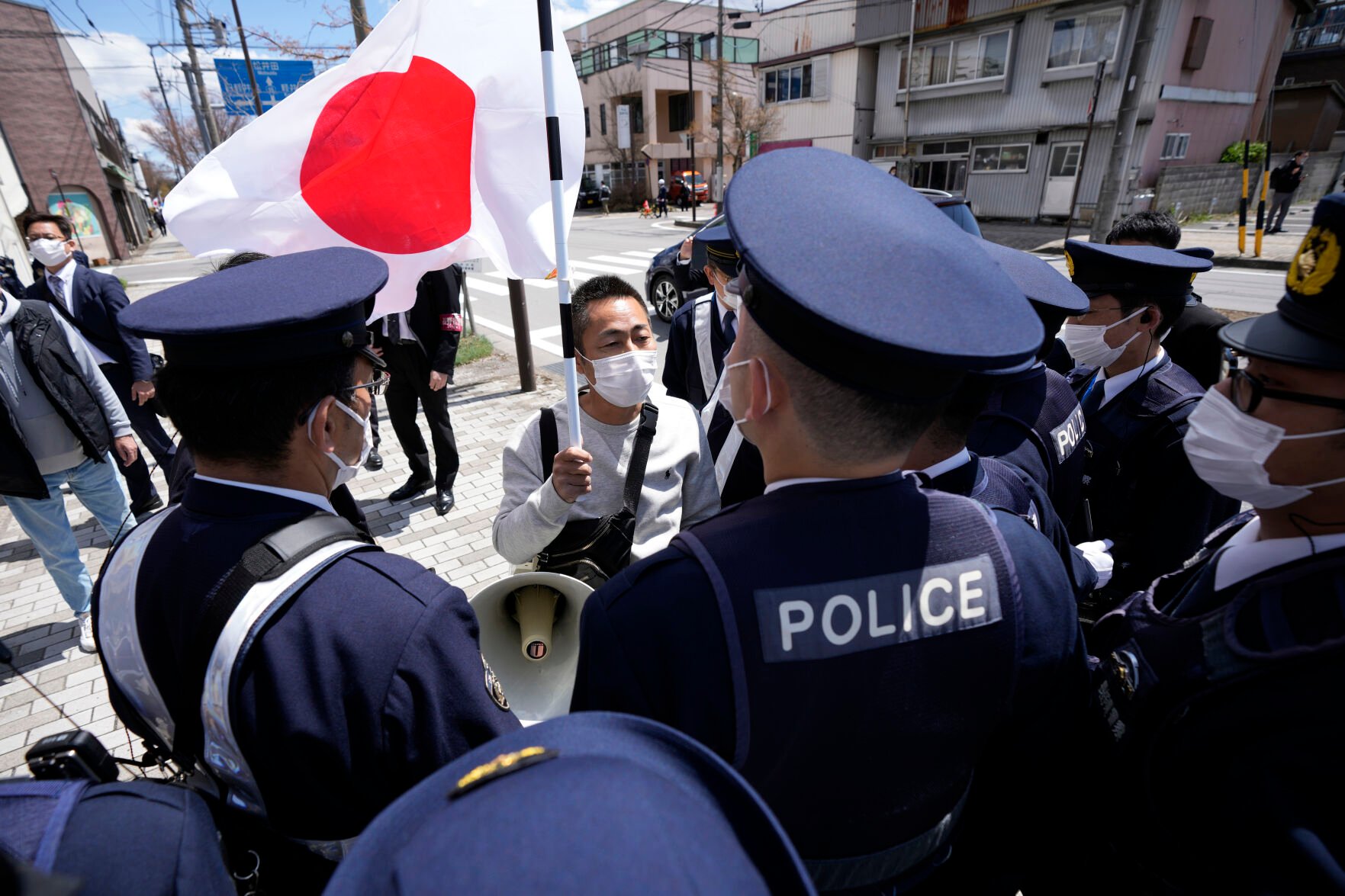 <p>A person holding a Japanese flag is surrounded by police officers on a street ahead of the G7 Foreign Ministers' Meeting on Sunday in Karuizawa, a resort town north of Tokyo.</p>
