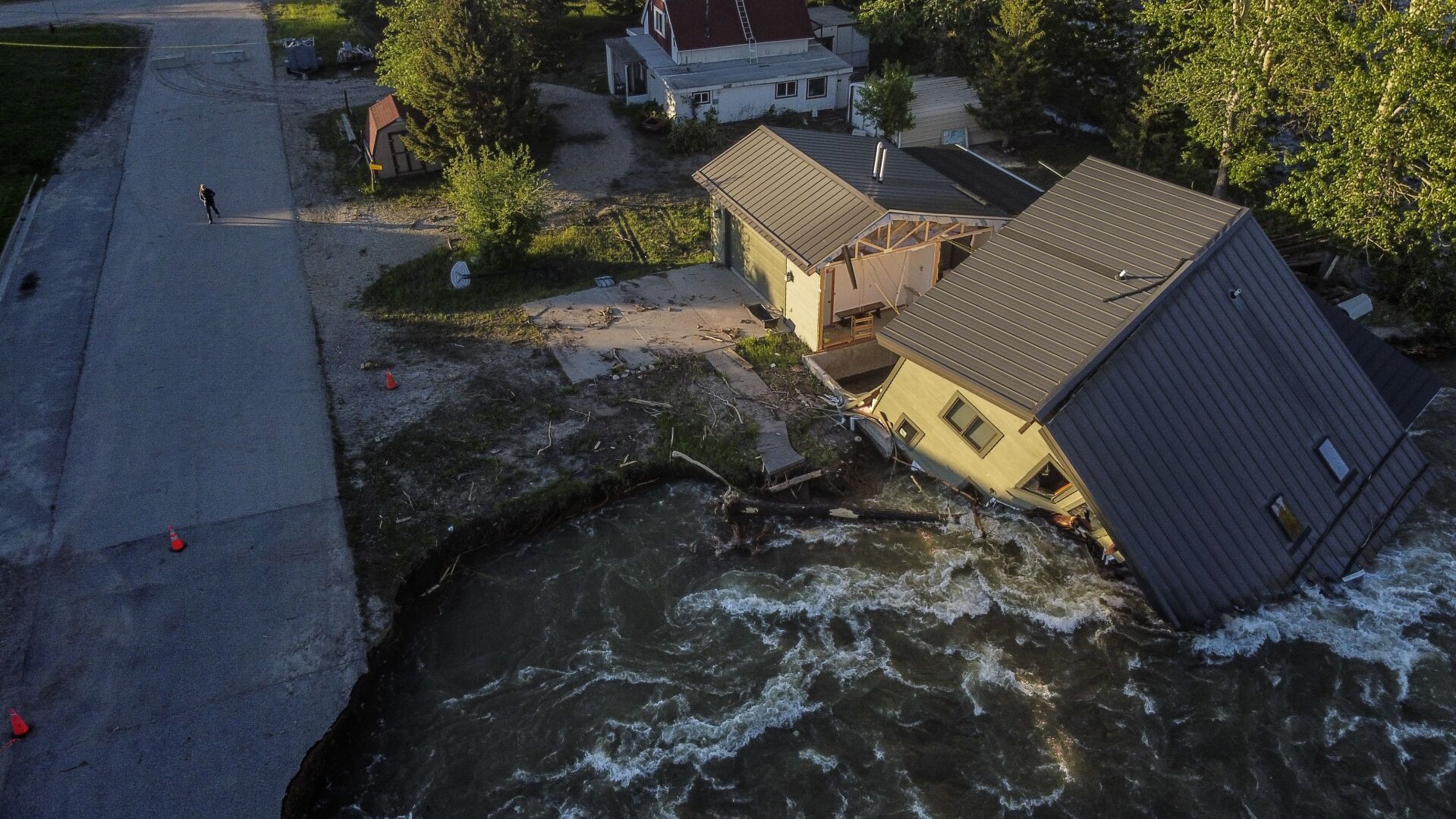 <p>A house sits in Rock Creek after floodwaters washed away a road and a bridge in Red Lodge, Mont., on June 15, 2022. </p>