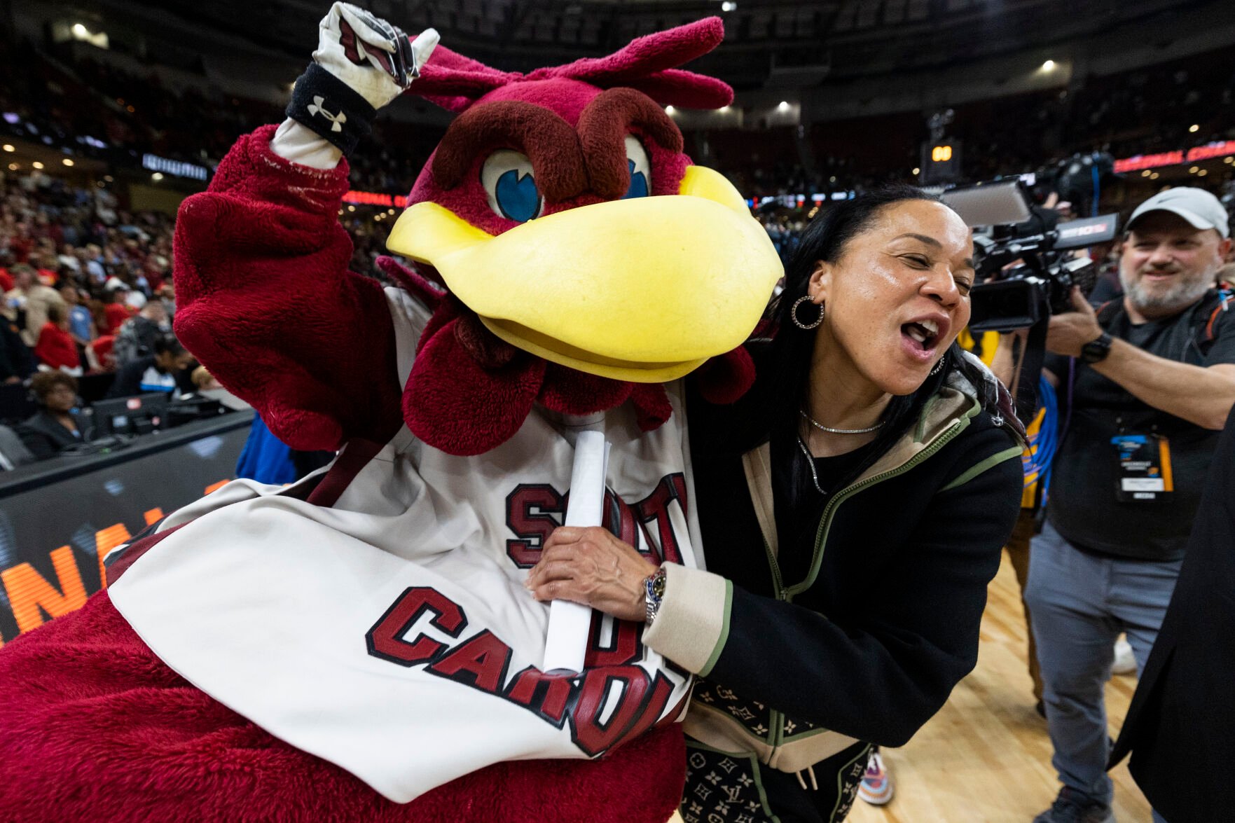 <p>South Carolina head coach Dawn Staley celebrates with school mascot "Cocky" after defeating Maryland in a March 27 Elite 8 game in Greenville, S.C.</p>