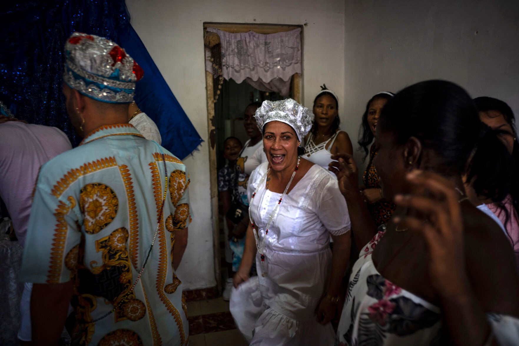 <p>Maritza de la Rosa Perdomo, center, dances before a blue altar during a Santería ceremony Nov. 13 in Havana, Cuba.</p>