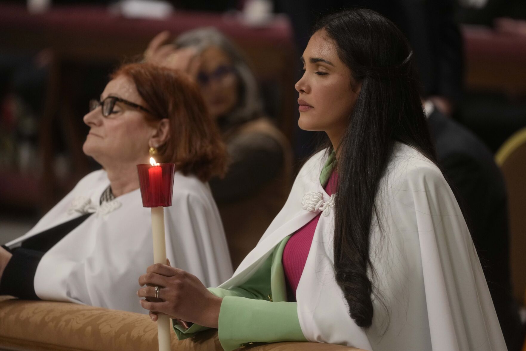 <p>Members of the faithful who were being baptized Saturday hold candles as Pope Francis presides over an Easter vigil ceremony in St. Peter's Basilica at the Vatican.</p>