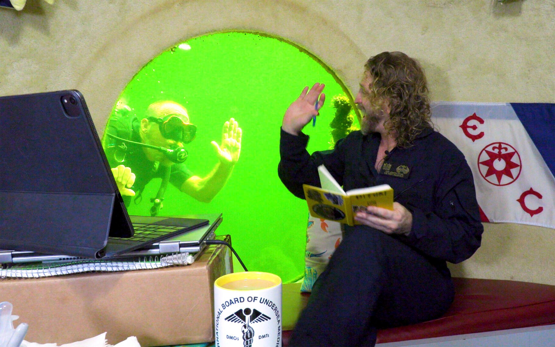 <p>In this photo provided by the Florida Keys News Bureau, diving explorer and medical researcher Dr. Joseph Dituri, right, waves to scuba diver Thane Milhoan, left, Saturday, May 13, 2023, while in Jules' Undersea Lodge, positioned at the bottom of a 30-foot-deep lagoon in Key Largo, Fla. </p>