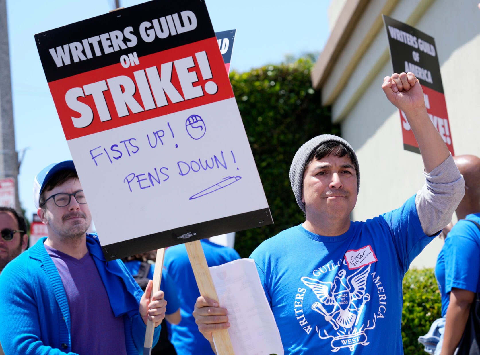 <p>Writers Guild of America West member Victor Duenas pickets with others at an entrance to Paramount Pictures on Tuesday in Los Angeles. </p>