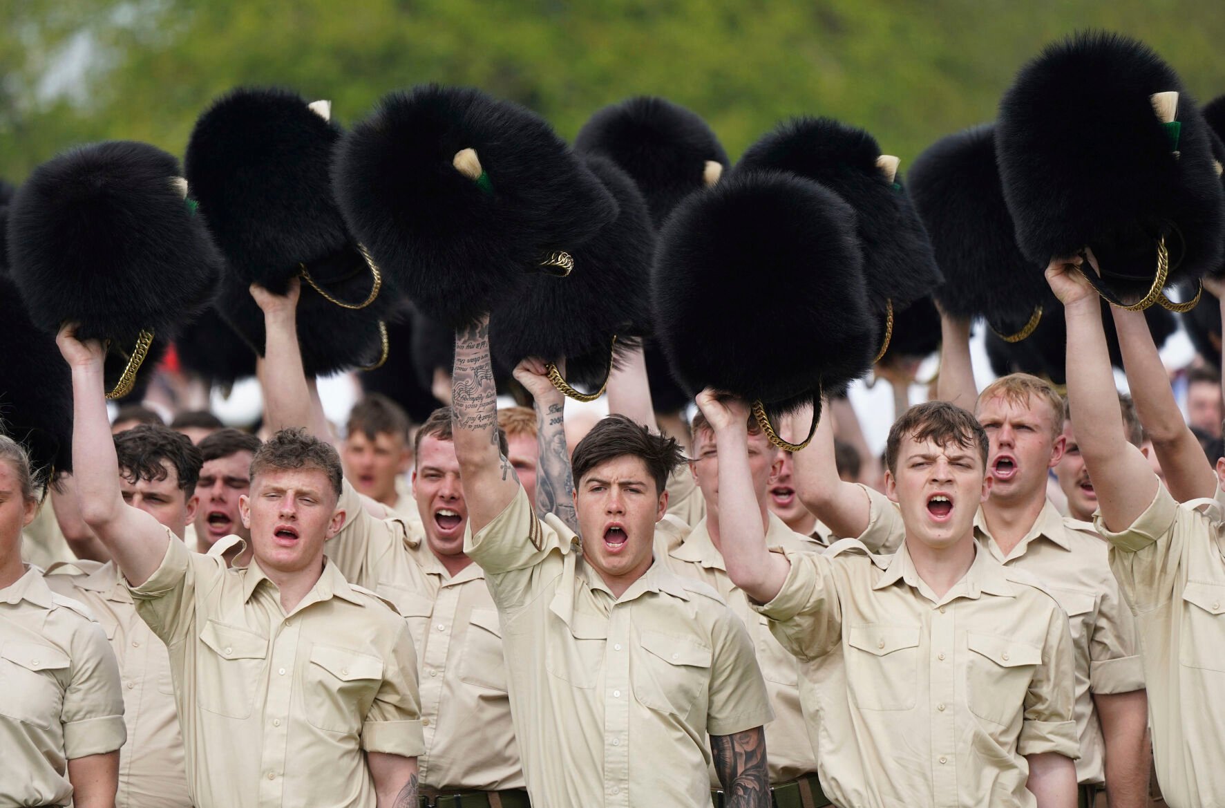 <p>Members of the Welsh Guards remove their head dress as they give three cheers for King Charles III during a full tri-service and Commonwealth rehearsal April 30 at RAF Odiham in Hook, England. The practice came ahead of their involvement in the second procession that accompanies King Charles III and Queen Camilla from Westminster Abbey back to Buckingham Palace, following the coronation service Saturday.</p>