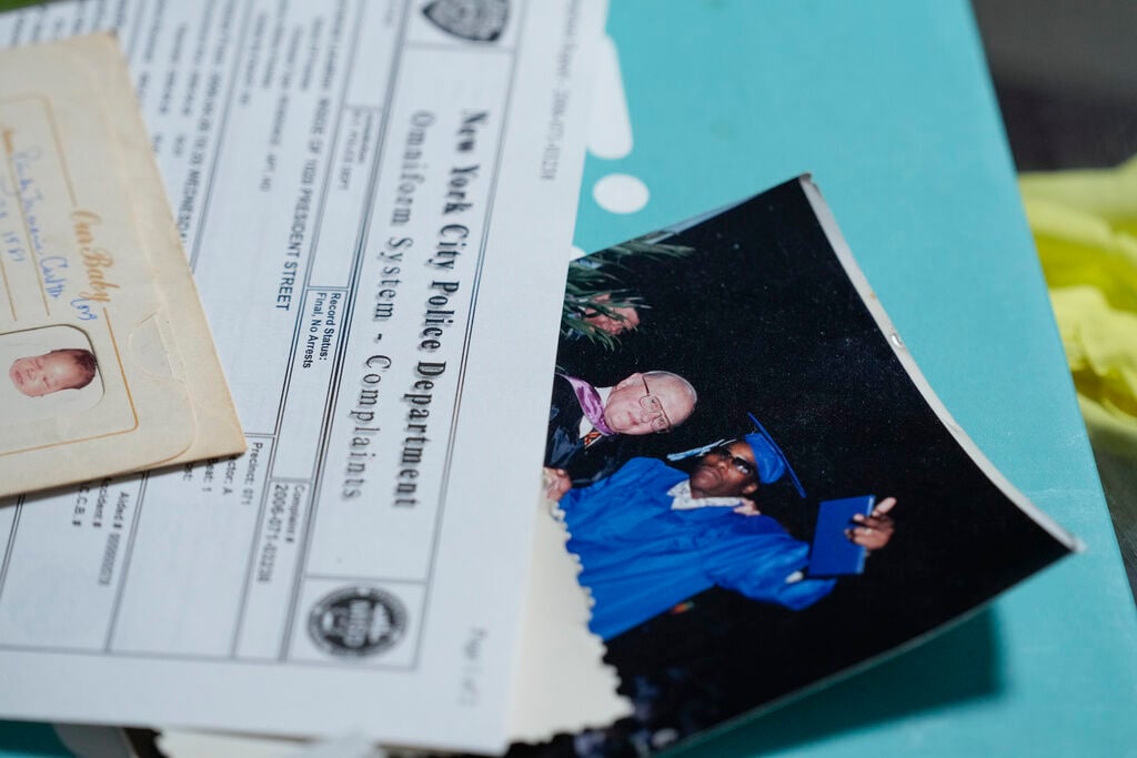 <p>Debra Long looks through documents about the murder of her son, Randy Long, and photographs from his life, at her home in Poughkeepsie, N.Y., on April 19.</p>