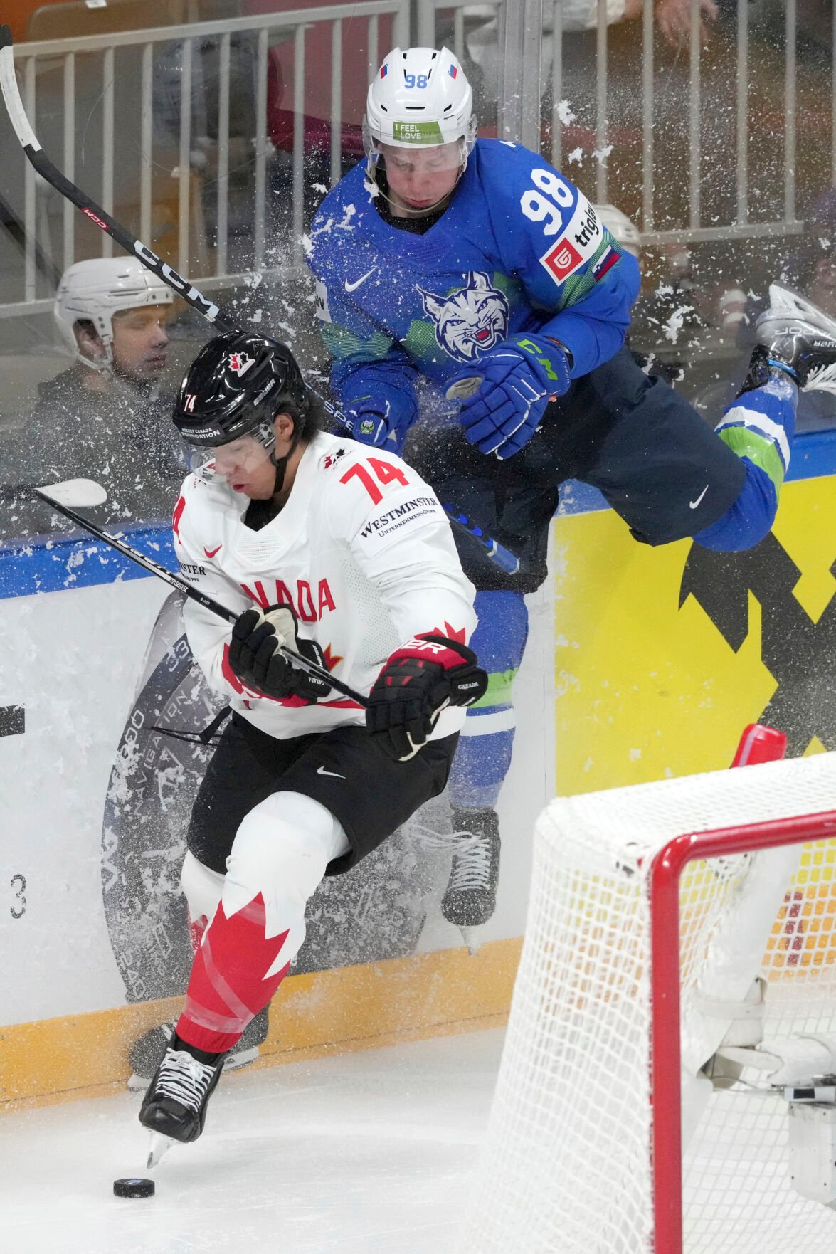 <p>Slovenia's Blaz Tomazevic, right, fights for a puck with Canada's Ethan Bear during a group B match on Sunday at the ice hockey world championship in Riga, Latvia.</p>