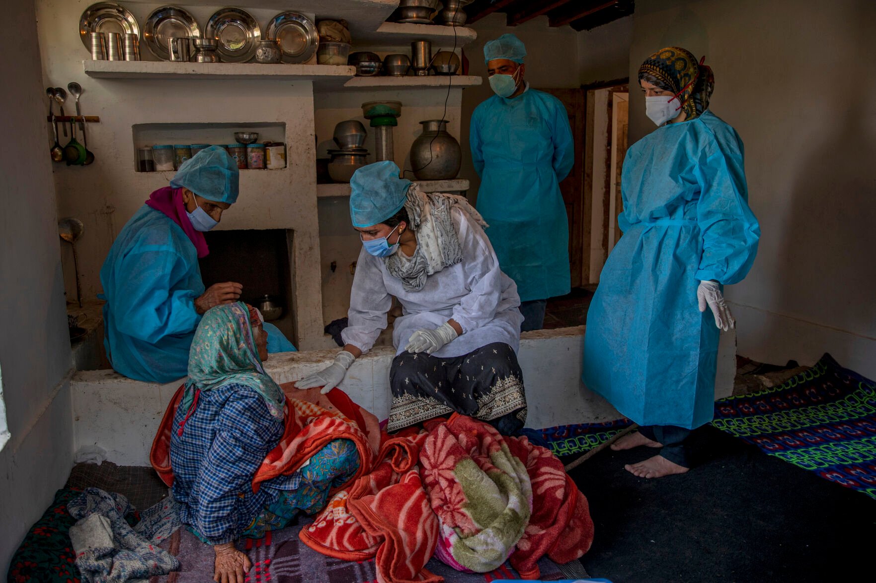 <p>Health workers talk to Khatija, an elderly tribal woman, to persuade her to take the COVID-19 vaccine June 5, 2021, in Doodkulan village south of Srinagar, Indian-controlled Kashmir.</p>