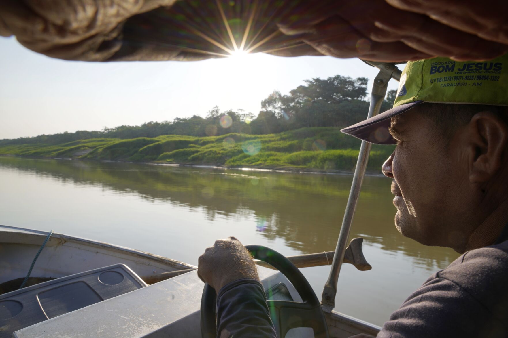 <p>Jose Alves de Morais maneuvers a boat, in Carauari, Brazil on Sept. 1, 2022. A Brazilian non-profit created a model for land ownership that welcomes both local people and scientists to collaborate in preserving the Amazon. "This is something that doesn't exist here in the Amazon, it doesn't exist anywhere in Brazil. If it works, which it will, it will attract a lot of people's attention," Morais, a resident, told The Associated Press. </p>