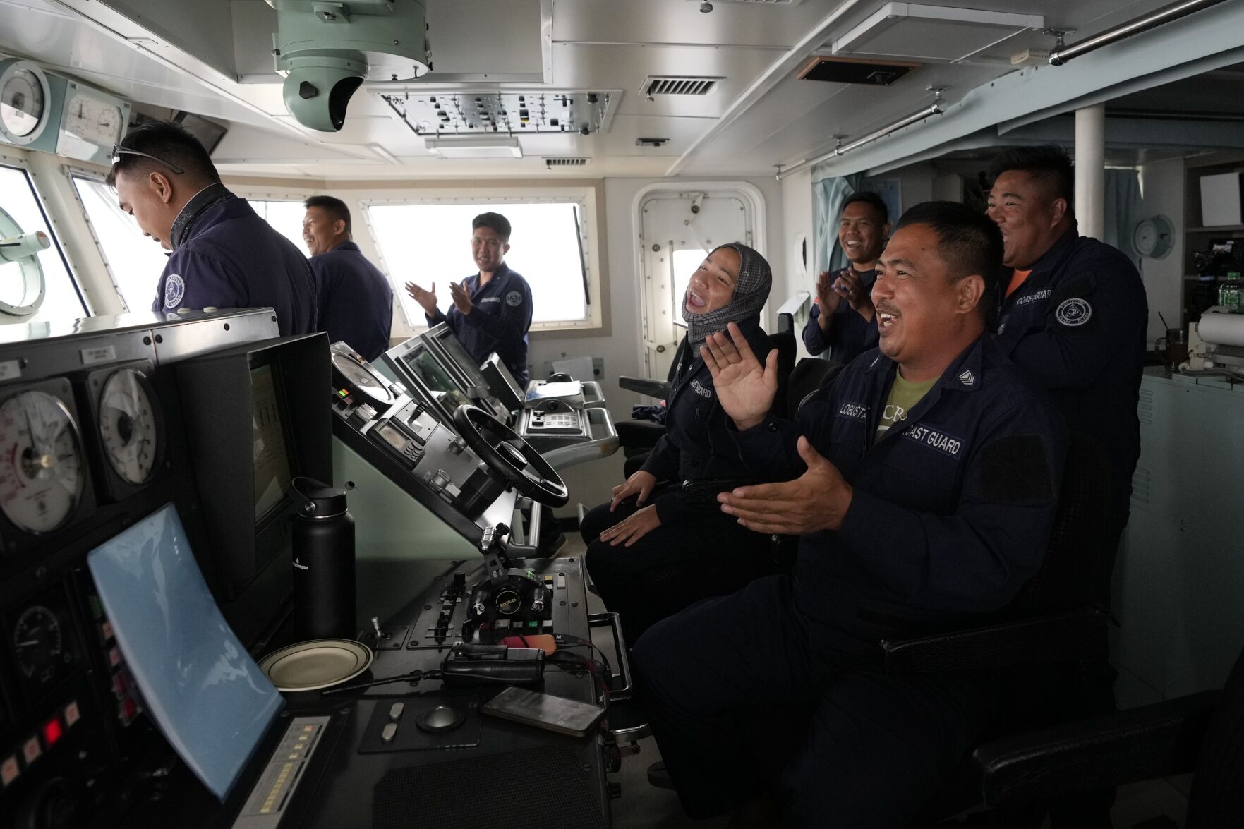 <p>Members of the Philippine Coast Guard sing a birthday song to one of their comrades April 22 on the navigational bridge of the BRP Malabrigo during a lull in activities as they patrol and resupply troops at Philippine-occupied areas in the South China Sea.</p>