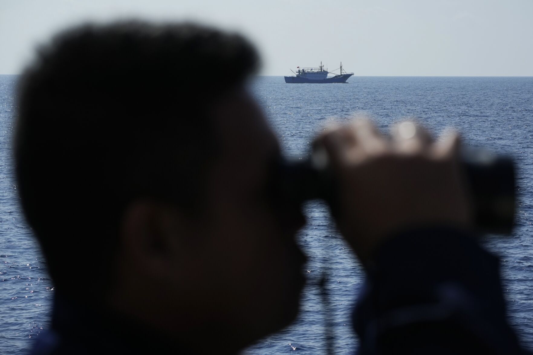 <p>A suspected Chinese militia ship passes as members on board the Philippine Coast Guard ship BRP Malabrigo drive them away April 21 from Philippine-occupied areas in the South China Sea.</p>