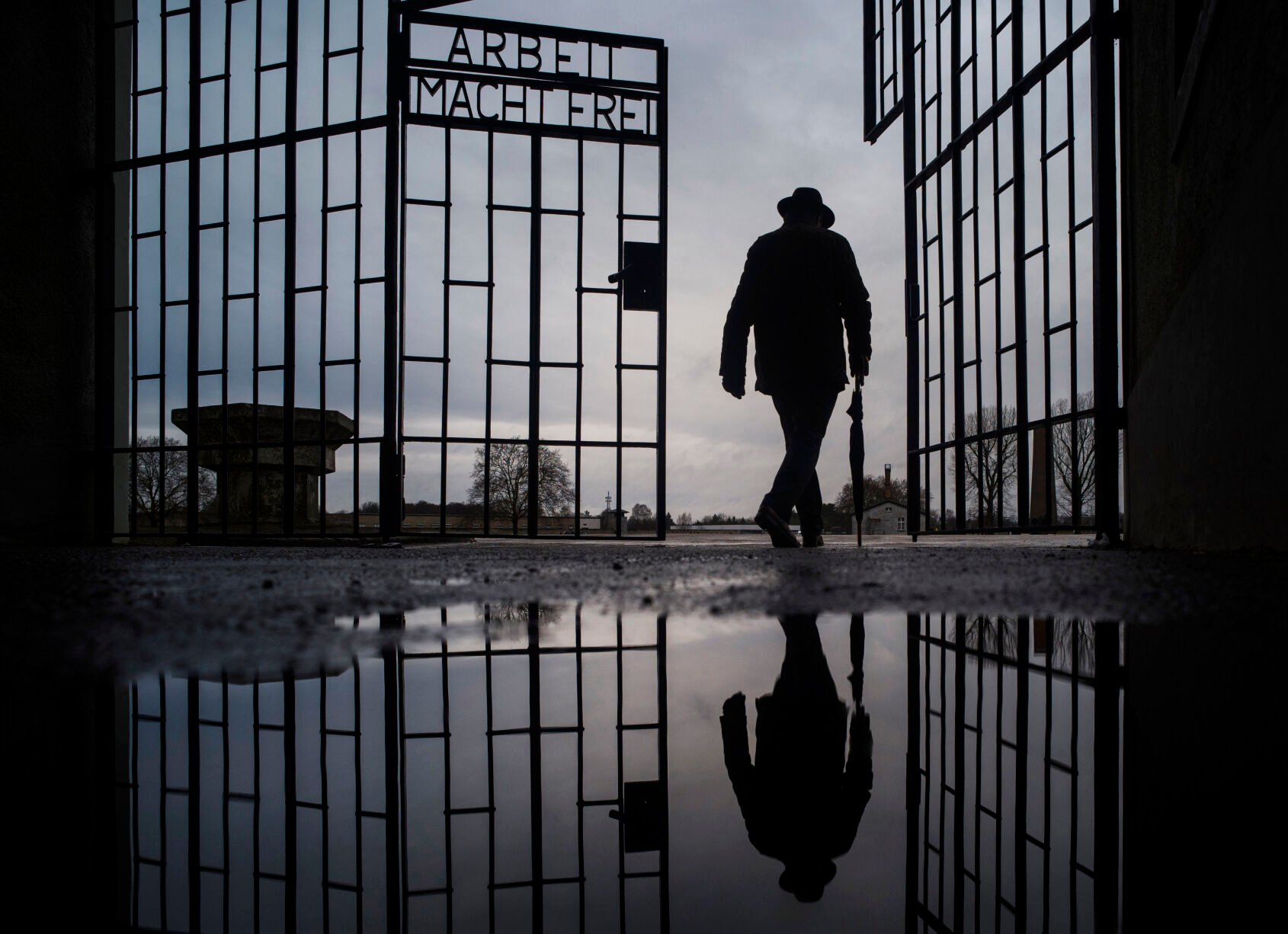 <p>A man walks through the gate of the Sachsenhausen Nazi death camp with the phrase Arbeit macht frei (work sets you free) at the International Holocaust Remembrance Day, in Oranienburg, north of Berlin, Germany, on Jan. 27, 2019. </p>