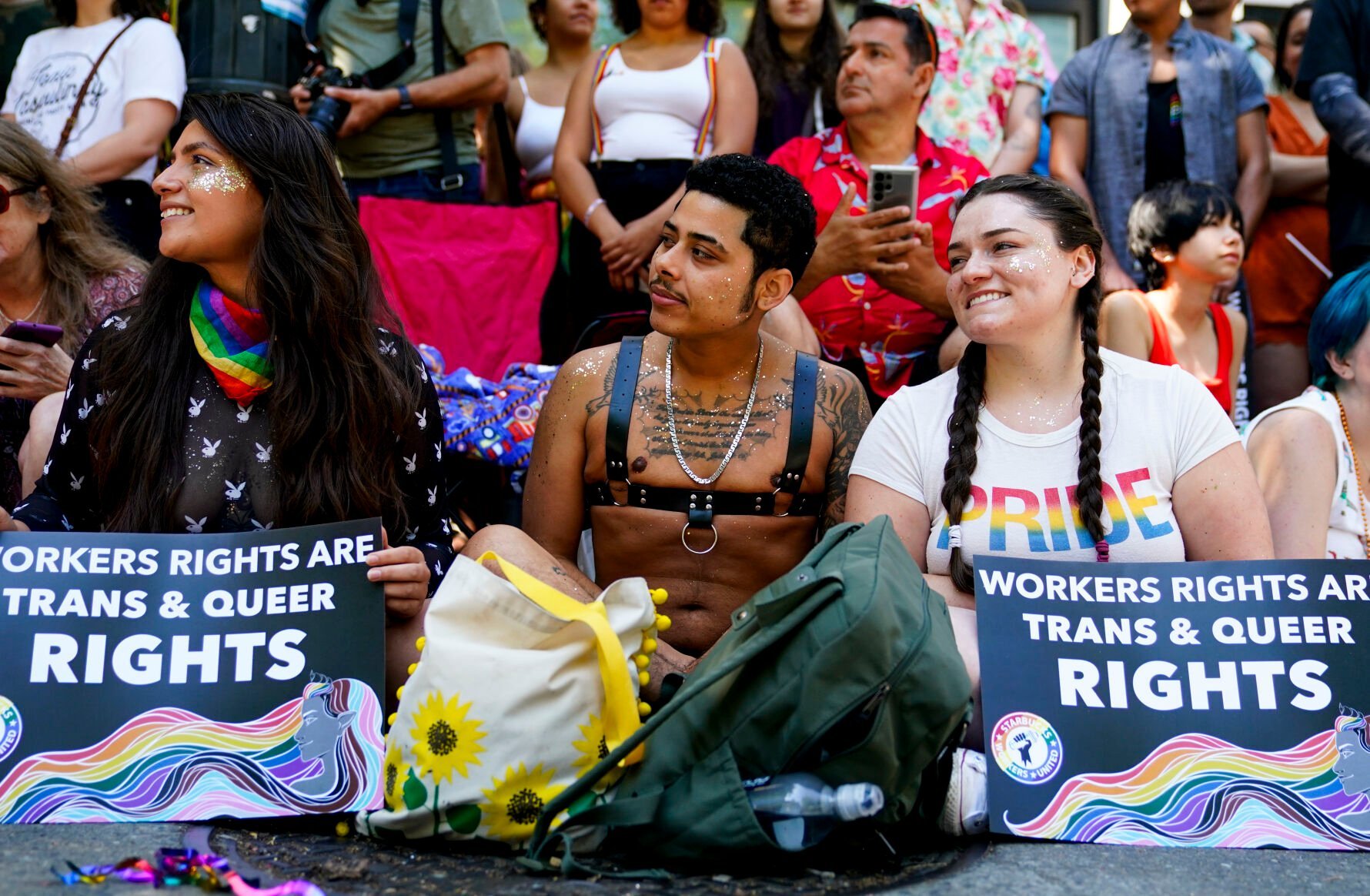 <p>Jessica Garcia, Erik Garcia and Meara White watch marchers in the annual Seattle Pride Parade on June 25. The union organizing Starbucks workers said Monday that a strike timed to Pride month closed 21 stores over the weekend.</p>