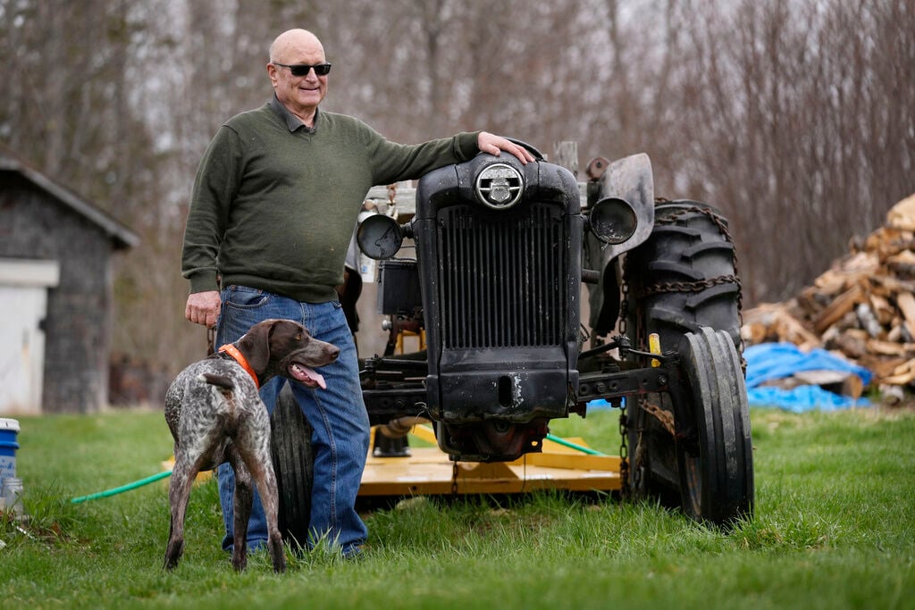 <p>Charlie Robbins stands next to his tractor at his home, April 26, in Columbia Falls, Maine. Robbins, an ardent sportsman, is opposed to a plan to build an enormous flagpole and theme park on undeveloped land cherished by hunters and fishermen.</p>