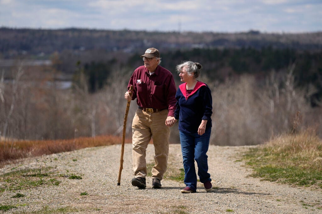 <p>Dell and Marie Emerson walk behind their home, April 27, in Addison, Maine. The couple is opposed to a flagpole theme park that would destroying woodlands and supplant wild blueberry barrens that have been farmed by Native Americans for 10,000 years.</p>