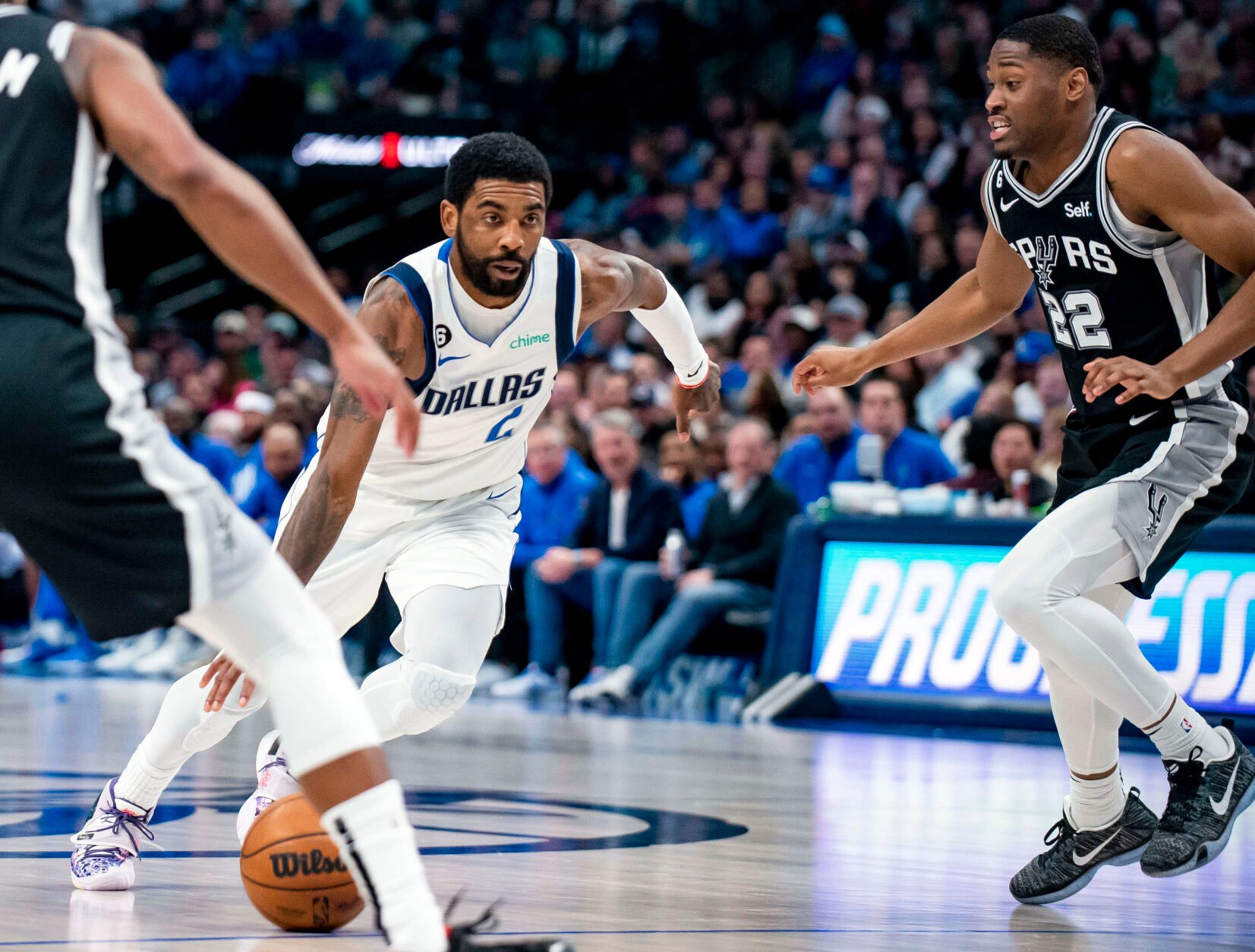 <p>Dallas Mavericks guard Kyrie Irving, center, drives past San Antonio Spurs guard Malaki Branham, right, during a Feb. 23 game in Dallas.</p>