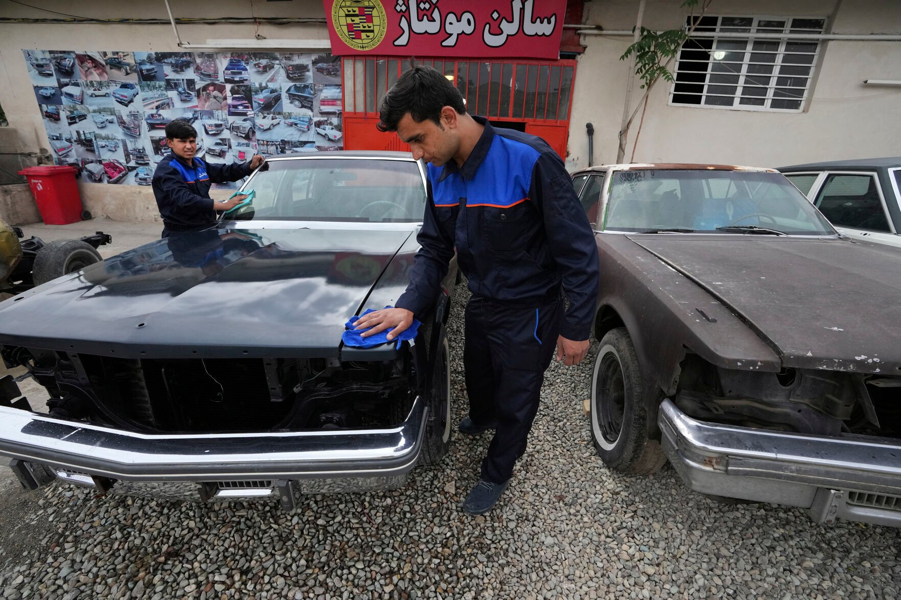 <p>Workers clean an under-restored Cadillac Seville at Khosro Dahaghin's workshop in Roudehen, Iran, on June 7.</p>