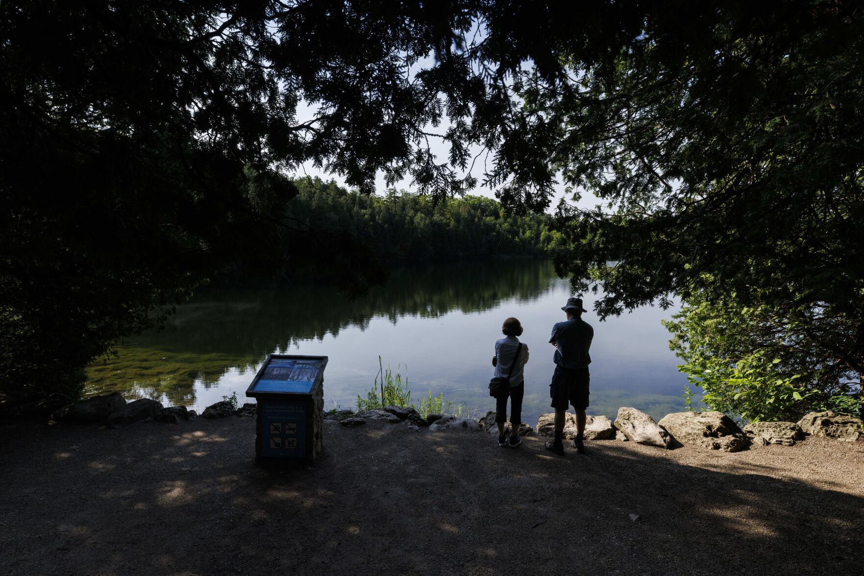 <p>People look out at the water Friday at Crawford Lake in Milton, Ontario.</p>