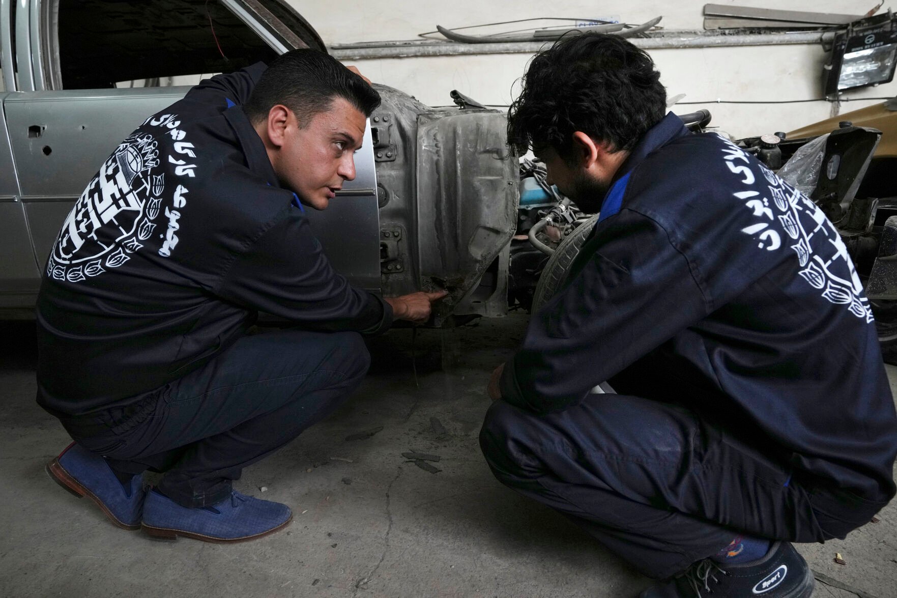 <p>Khosro Dahaghin, left, talks with a worker at his workshop while restoring a Cadillac Seville in Roudehen, some 30 miles east of downtown Tehran, Iran, on June 7.</p>