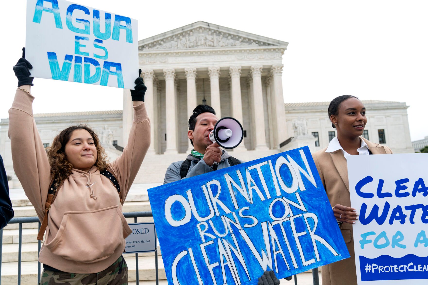 <p>FILE - Bethsaida Sigaran, left, of Baltimore, her brother Jaime Sigaran, with American Rivers, and Thea Louis, with Clean Water Action, join supporters of the Clean Water Act as they demonstrate outside the Supreme Court, Oct. 3, 2022, in Washington.</p>