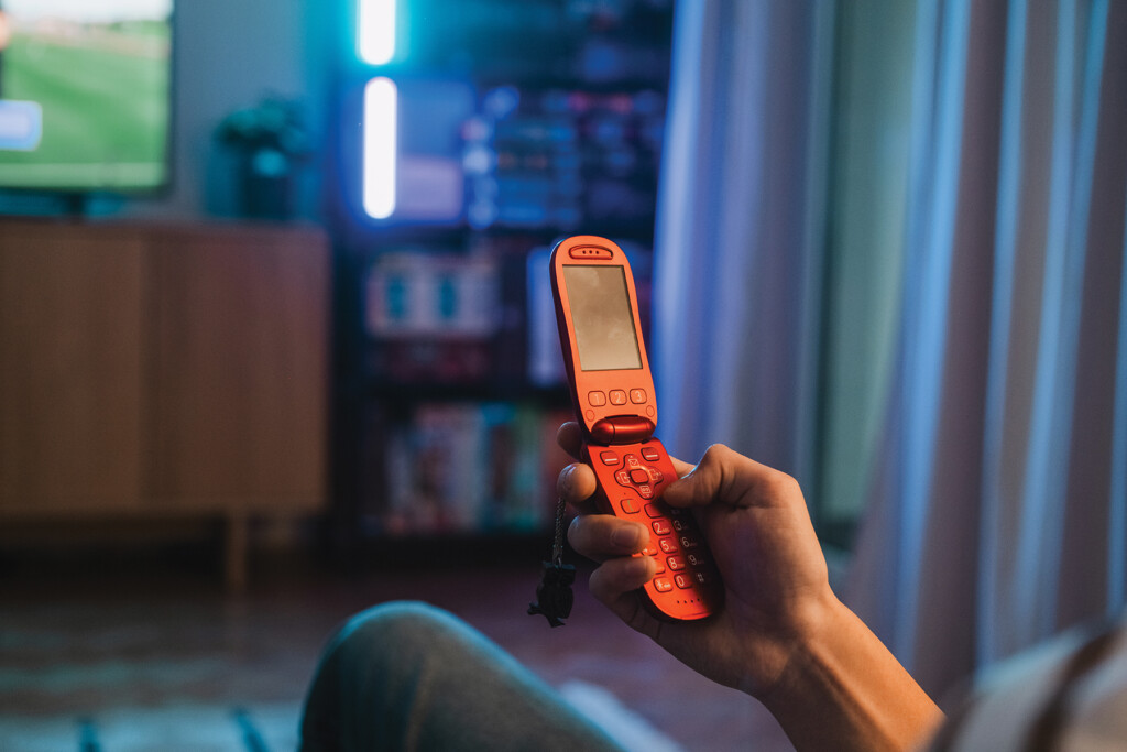 Person Using A Retro Flip Phone At Home